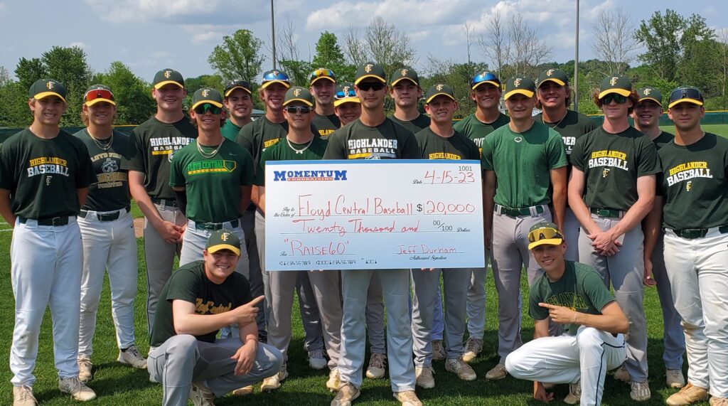 A baseball team holds a large check for $20,000 labeled “Floyd Central Baseball ‘Raise 60.”.